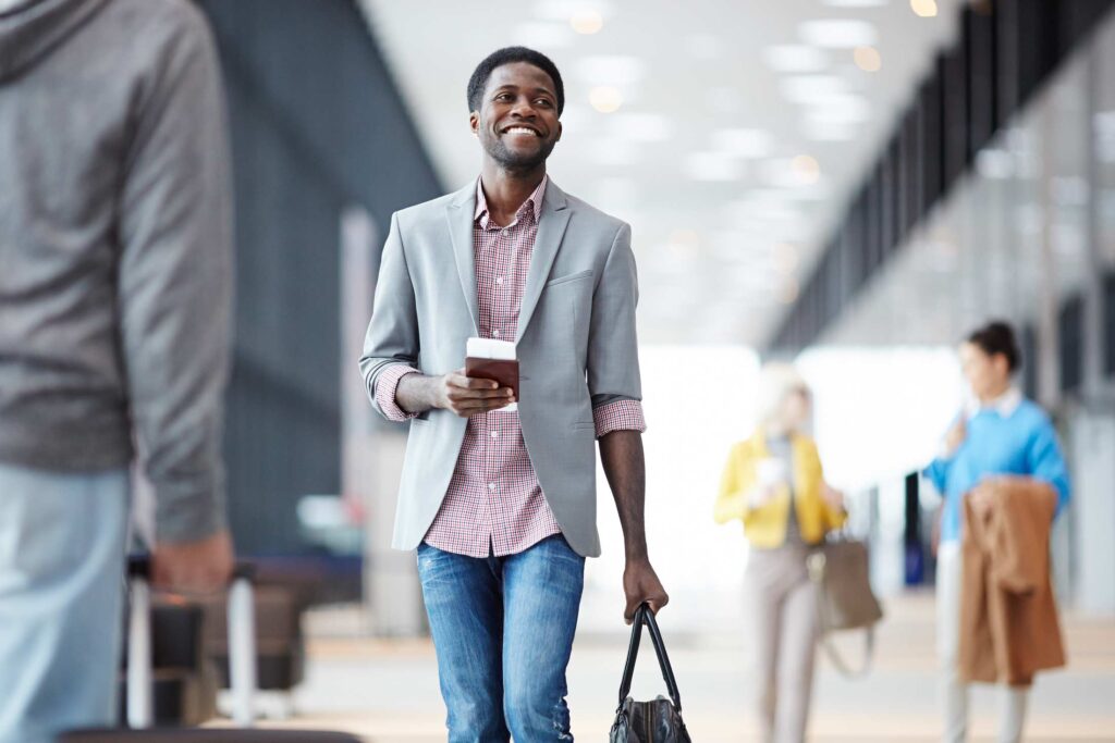 Man standing with passport in hall of airport