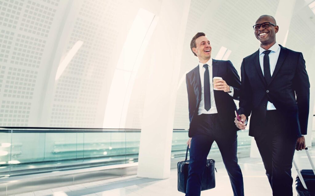 Businessmen walking through an airport talking together