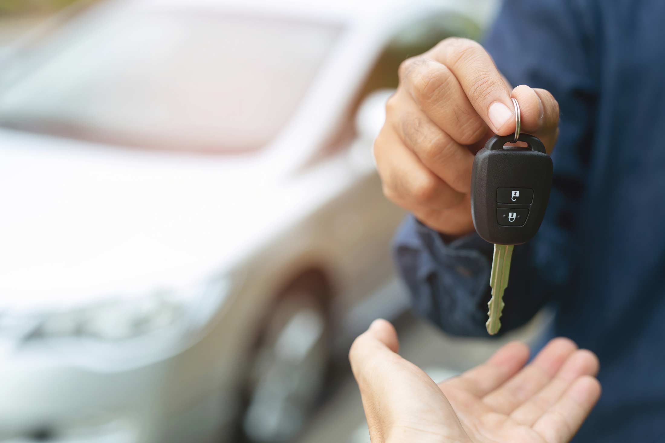 Man handing keys to another person