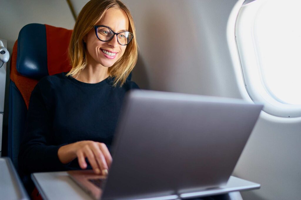 Businesswoman working on laptop on an airplane.
