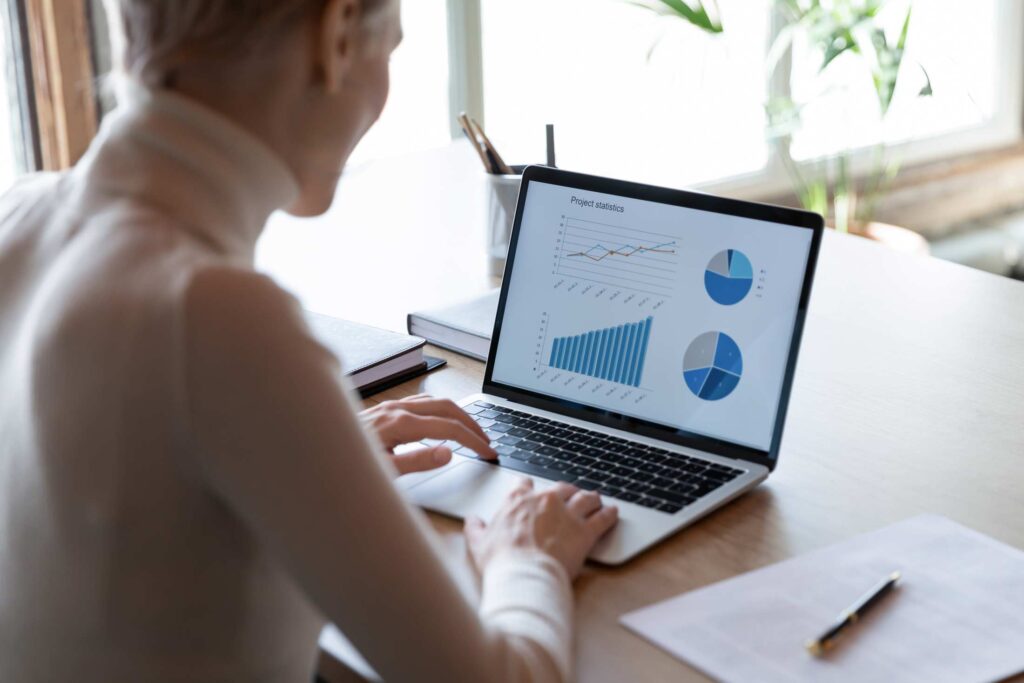 Businesswoman working with financial project statistics on laptop