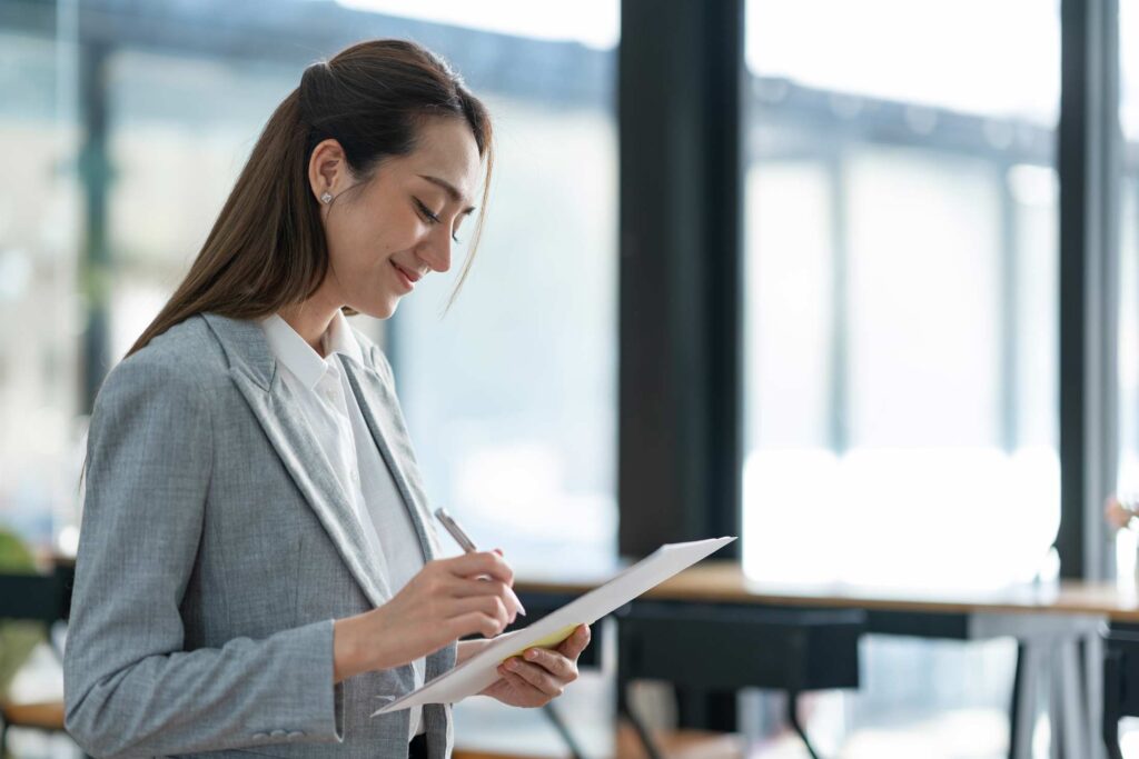 Businesswoman checking a document on a clipboard