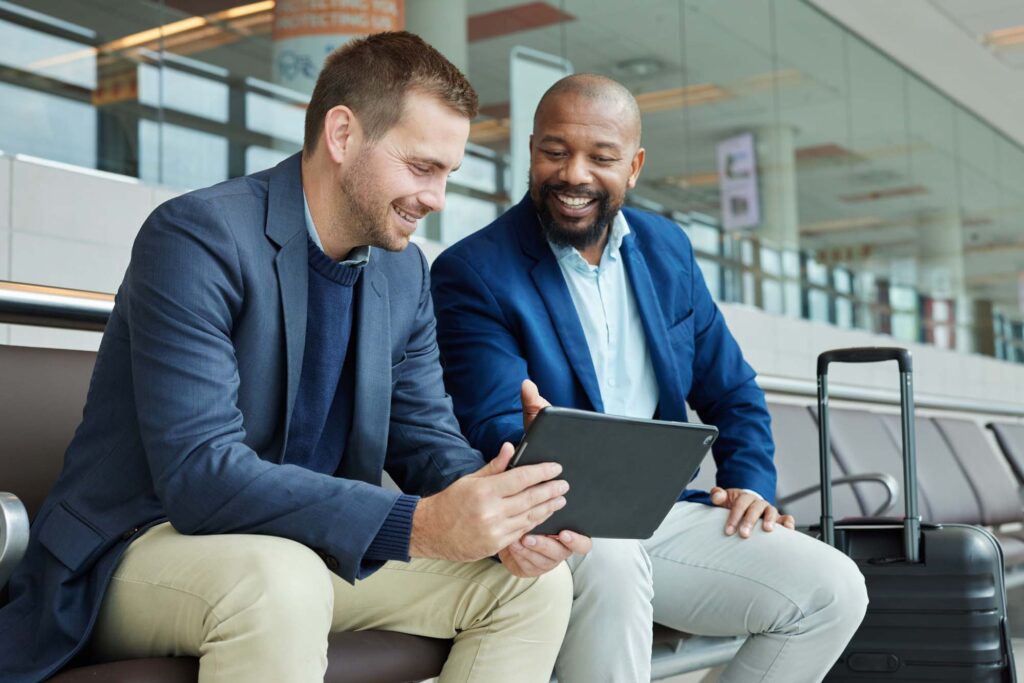 Airport, business team people and tablet talking of flight schedule, travel news or fintech management. Happy investment black man, international partner and digital technology for immigration advice.