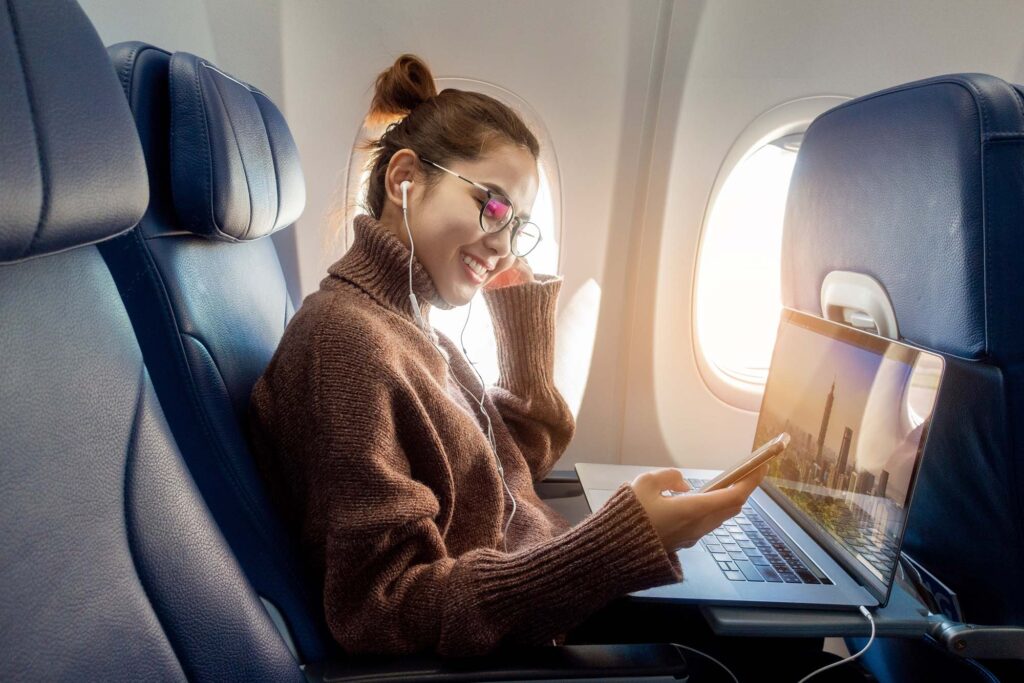 Woman working with laptop in airplane
