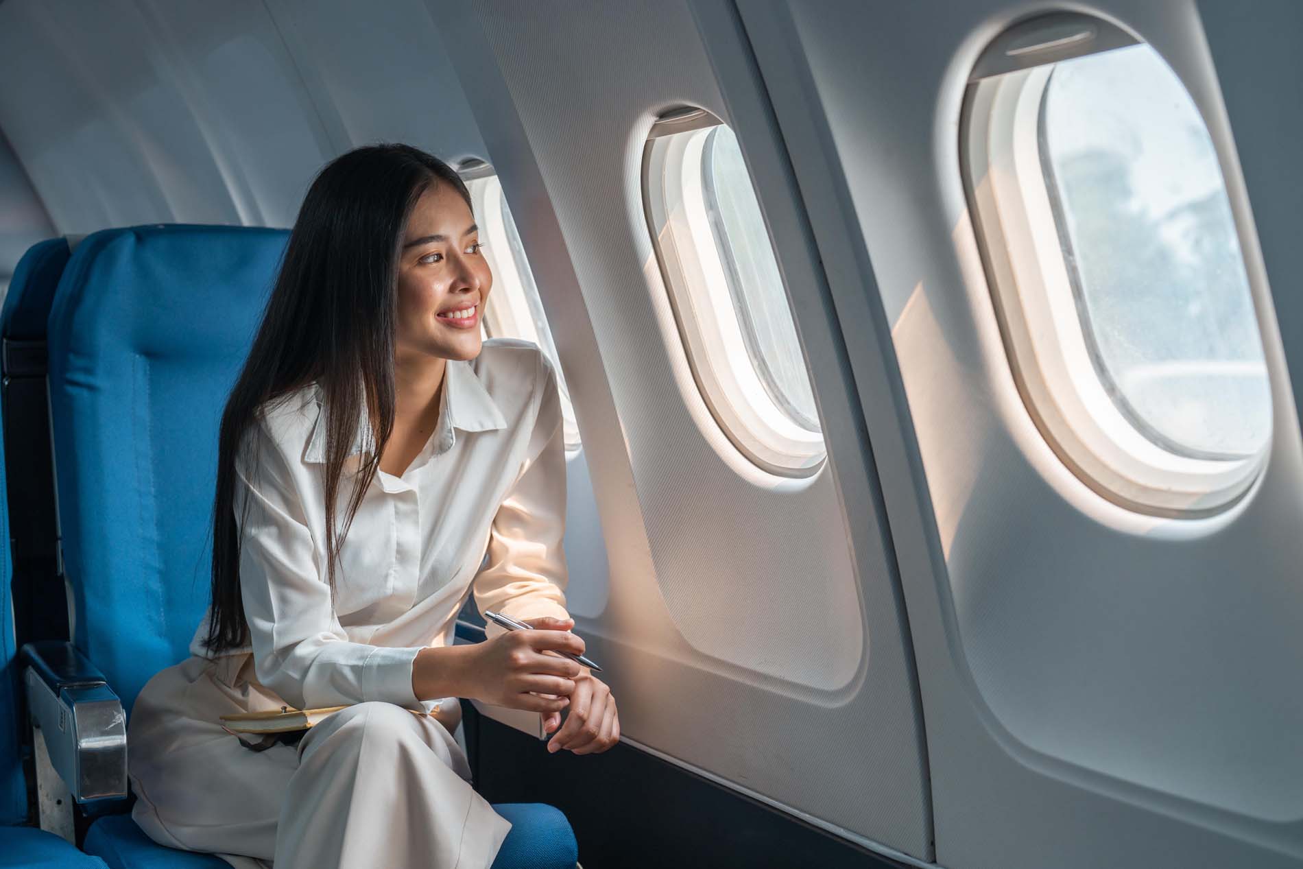 Woman sitting in a seat in airplane and looking out the window