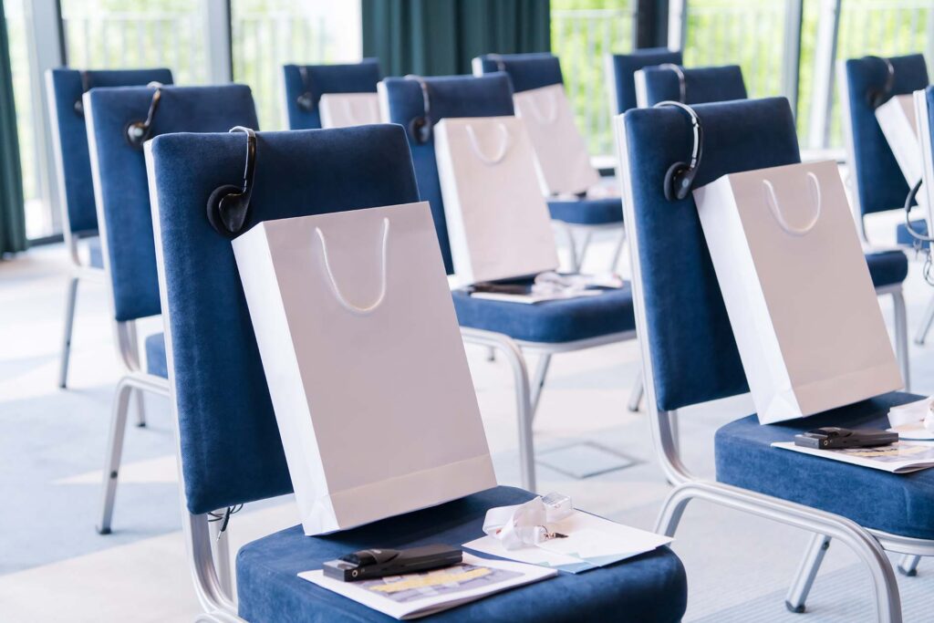 Conference room with chairs in rows and a gift bag on each chair