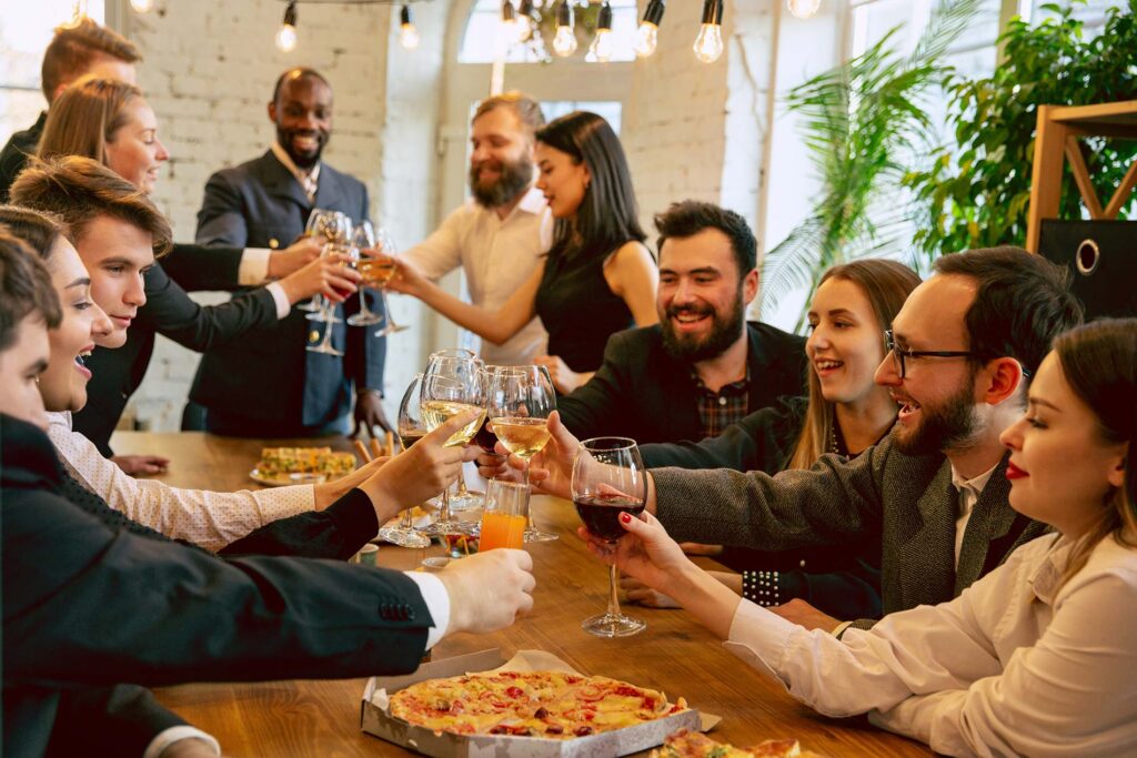 Group of formally dressed individuals toasting at a dinner party