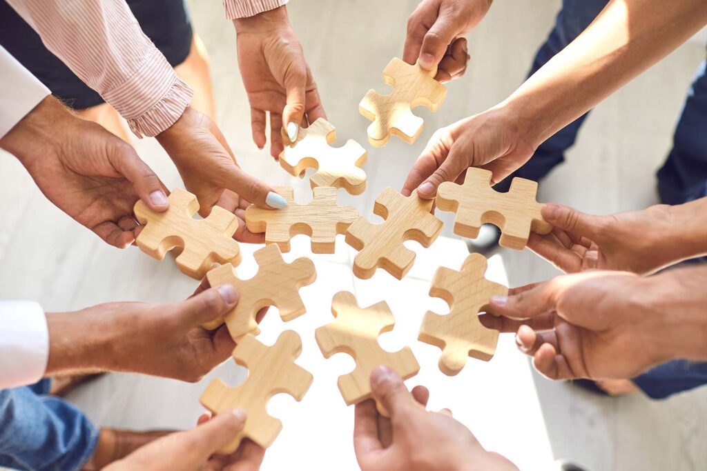 People with pieces of a puzzle in their hand to make complete