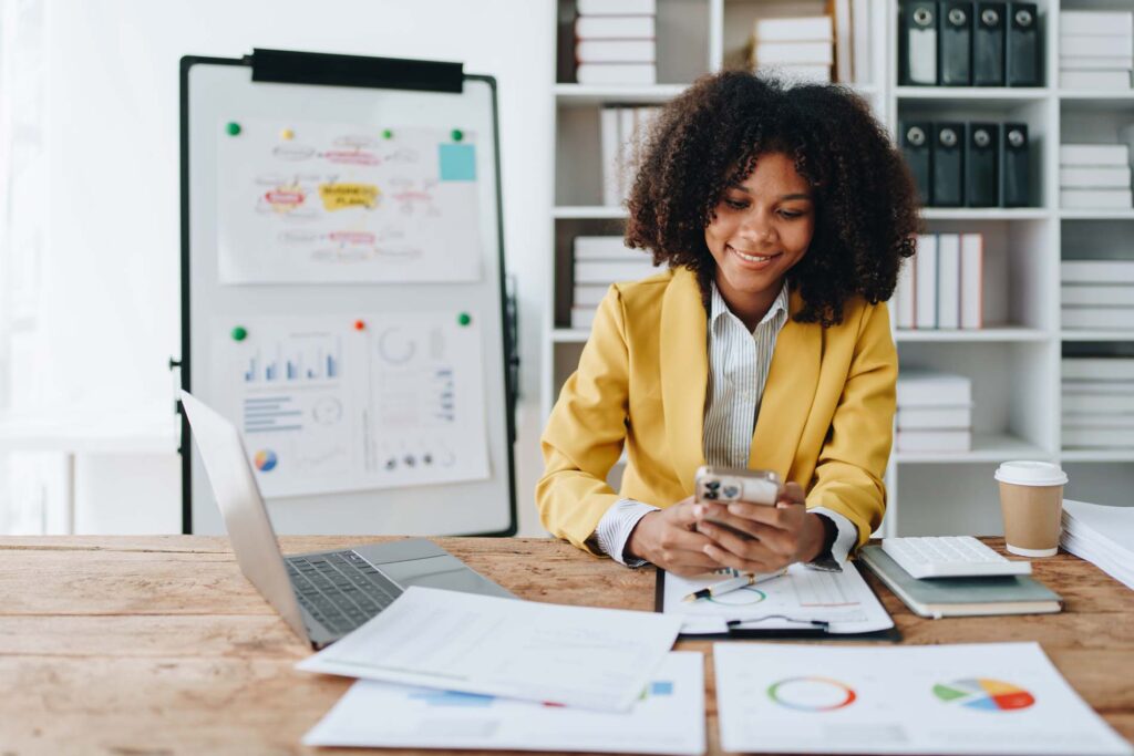 Woman using smart phone mobile and laptop computer with planning working on financial document, tax, exchange, accounting and Financial advisor