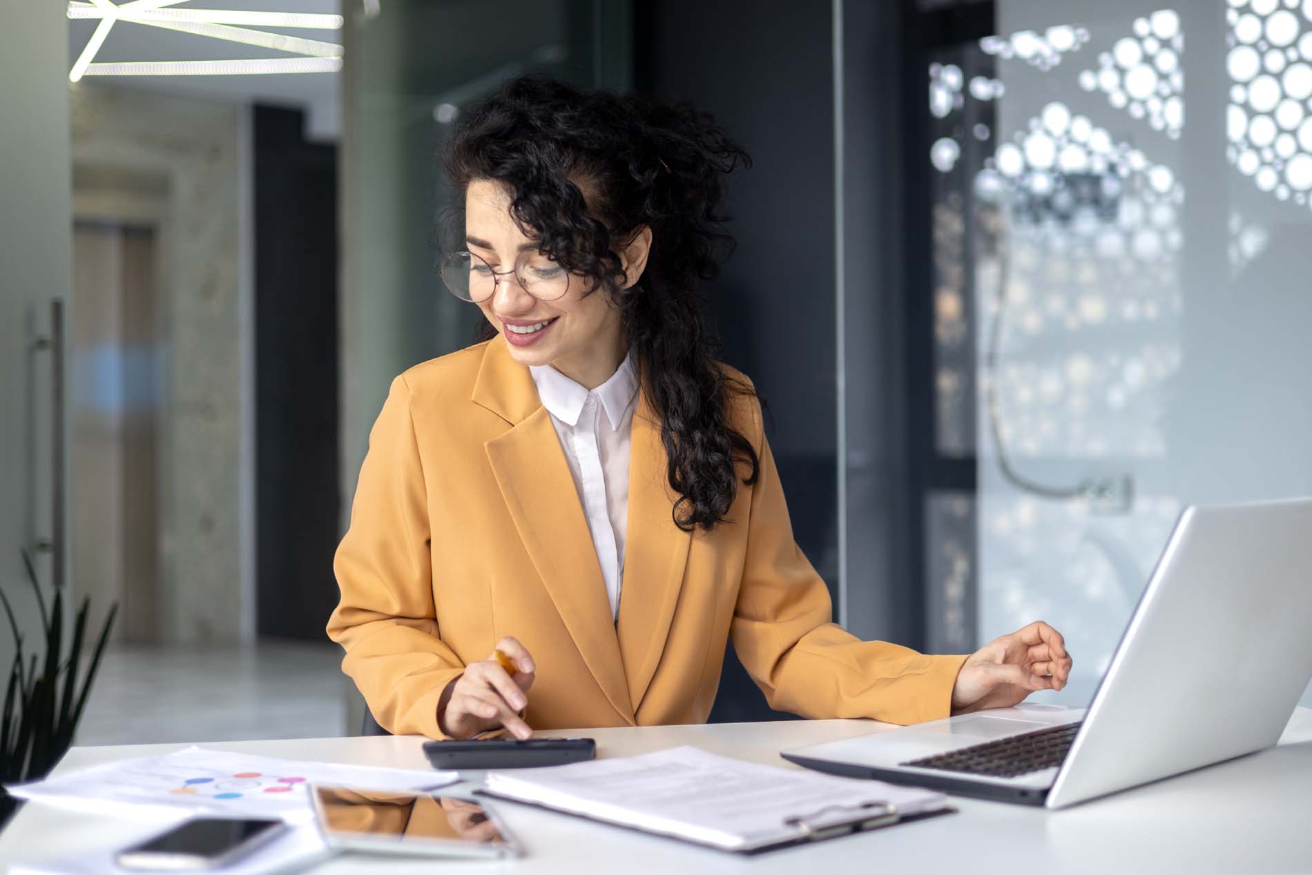 Mature successful financier accountant on paper work with papers, documents contracts and charts graphs, businesswoman boss with calculator smiling happy with achievement results, inside office