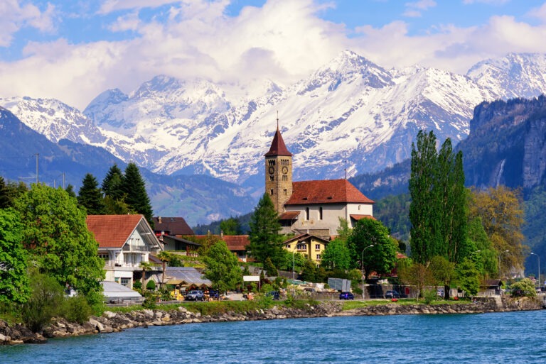 Brienz town on Lake Brienz by Interlaken, Switzerland, with snow covered Alps mountains in background