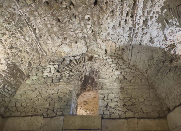 Split, Croatia - July 1, 2024: Historic Diocletian Cellars and palace. Open connecting niche in wall full of cracks, holes. Bowed ceiling in front
