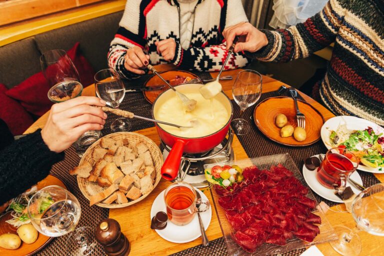 Friends eating cheese fondue in a cozy traditional swiss restaurant