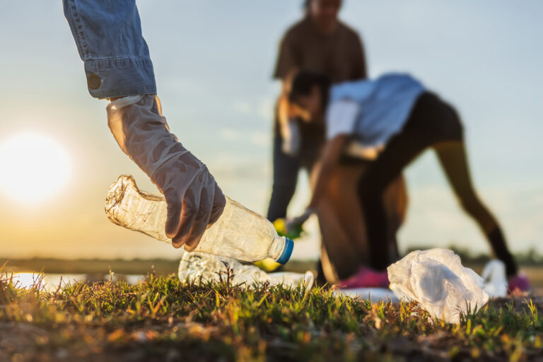 people volunteer keeping garbage plastic bottle into black bag a