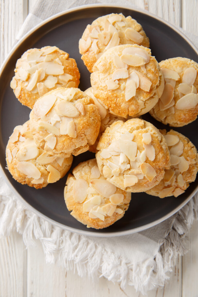 almond shortbread gluten-free cookies in a plate on a wooden table. Vertical top view from above